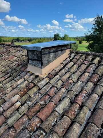 Réparation d’une cheminée en zinc avec chapeau sur mesure et entourage bétonné près de Bergerac