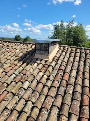 Réparation d’une cheminée en zinc avec chapeau sur mesure et entourage bétonné près de Bergerac